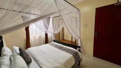 a bedroom with a canopy bed with a window at Ultra Home Apartment in Themi