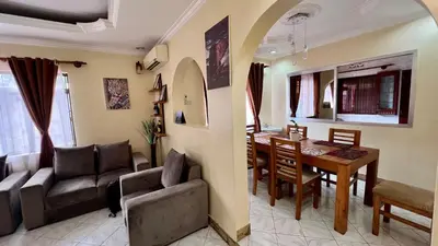 a living room and dining room with a table and chairs at Ultra Home Apartment in Themi