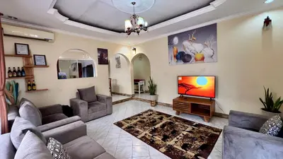 a living room with two couches and a television at Ultra Home Apartment in Themi