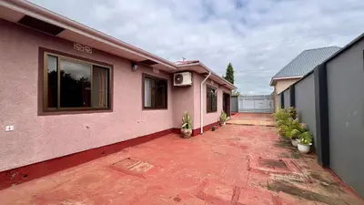 a pink house with a patio with plants at Ultra Home Apartment in Themi