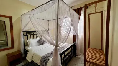 a bedroom with a canopy bed with white drapes at Ultra Home - Bed and Breakfast in Themi