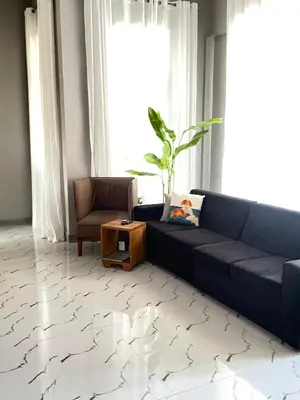 a living room with a blue couch and a chair at Stay with Rodjazz in Usa River