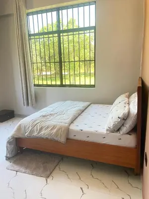 a bed in a bedroom with a window at Stay with Rodjazz in Usa River