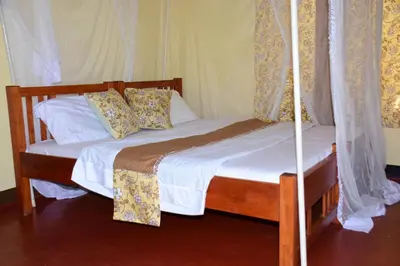 a bedroom with two twin beds with curtains at Hostel in Tengeru