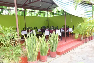a restaurant with tables and chairs and potted plants at Hostel in Tengeru