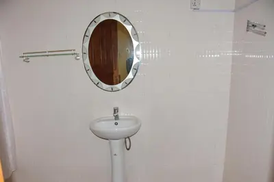 a bathroom with a sink and a mirror on the wall at Hostel in Tengeru