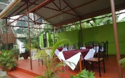 a room with a table and chairs and a green wall at Urafiki House in Arusha