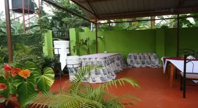 a patio with a table and chairs and plants at Urafiki House in Arusha