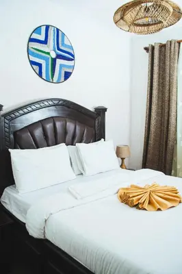 a bedroom with a bed with a blue and white sign on the wall at SAS Residence in Arusha