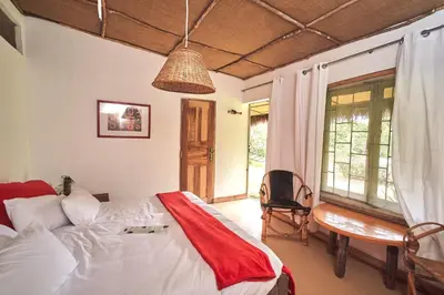a bedroom with a bed and a desk and a chair at Hillside Retreat – Africa Amini Life in Usa River