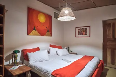 a bedroom with a bed and a painting on the wall at Hillside Retreat – Africa Amini Life in Usa River