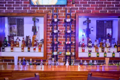 a bar with a bunch of bottles of alcohol at Orlando Cottages in Arusha