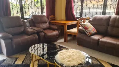 a living room with a leather couch and a table at Space haven 02 in Arusha