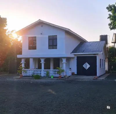 a white house with a blue garage at Space haven 02 in Arusha