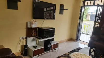 a living room with a tv on the wall at Space haven 02 in Arusha