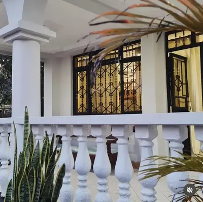 a house with a white railing and windows at Space haven 02 in Arusha