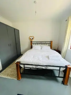 a bedroom with a bed in a white room at Bai-Mai Homes- Kijenge in Arusha