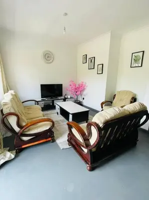 a living room with two chairs and a table at Bai-Mai Homes- Kijenge in Arusha