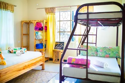 a bedroom with two bunk beds and a ladder at Msamaria Lori Hostel in Moshi