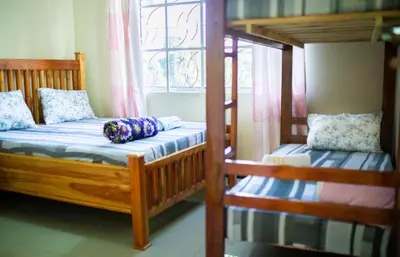 a bedroom with two bunk beds and a window at Msamaria Lori Hostel in Moshi