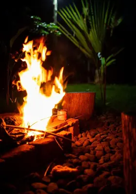 a fire burns in a fire pit at night at Msamaria Lori Hostel in Moshi