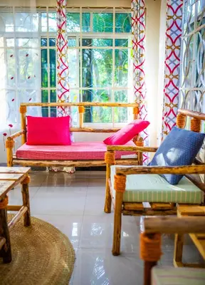 a living room with two chairs and a window at Msamaria Lori Hostel in Moshi