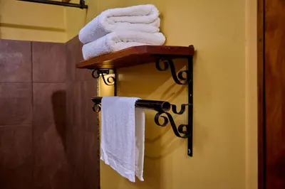 a towel rack with towels on it in a bathroom at Shamba Lodge Cabin X in Arusha