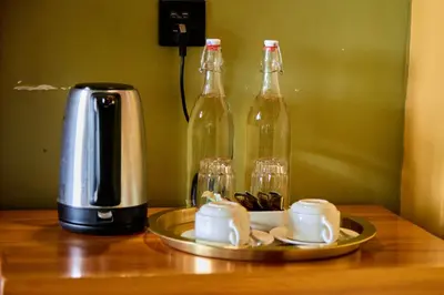 a coffee maker and two bottles on a table at Shamba Lodge Cabin X in Arusha