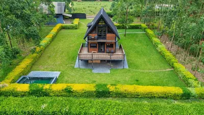 a small house on top of a green yard at Shamba Lodge Cabin X in Arusha