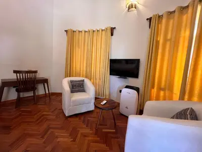 a living room with a couch chair and a tv at Kili Touch Apts in Arusha