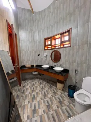 a bathroom with two sinks and a toilet at Kili Touch Apts in Arusha