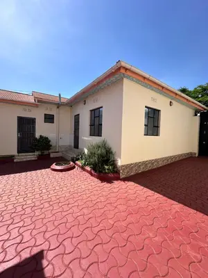 a house with a red brick driveway in front of it at Amora Homestay and Safaris in Karatu