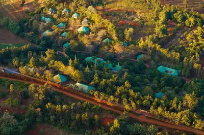 an aerial view of a farm with a train at Turaco Ngorongoro Valley, a Tribute Portfolio Lodge in Karatu