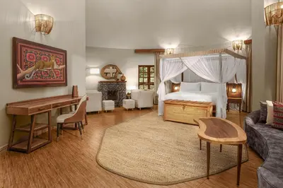 a bedroom with a bed and a living room at Turaco Ngorongoro Valley, a Tribute Portfolio Lodge in Karatu