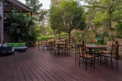 a deck with tables and chairs on a patio at Turaco Ngorongoro Valley, a Tribute Portfolio Lodge in Karatu