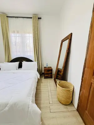 a hotel room with two beds and a mirror at Urban Nest in Arusha