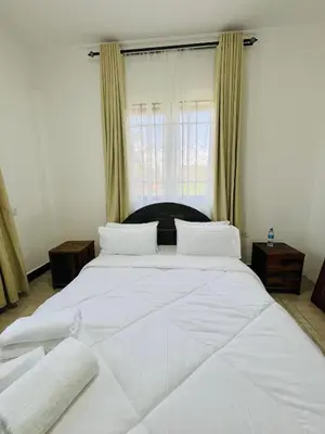 a large white bed in a bedroom with a window at Urban Nest in Arusha