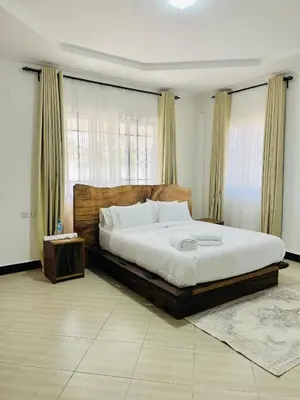 a bedroom with a large bed and a large window at Urban Nest in Arusha