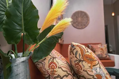 a vase with feathers in it next to two pillows at Ghala House Apartment Moshi in Moshi