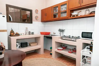 a small kitchen with wooden cabinets and a table at Ghala House Apartment Moshi in Moshi