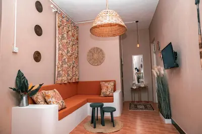 a living room with a couch and two stools at Ghala House Apartment Moshi in Moshi