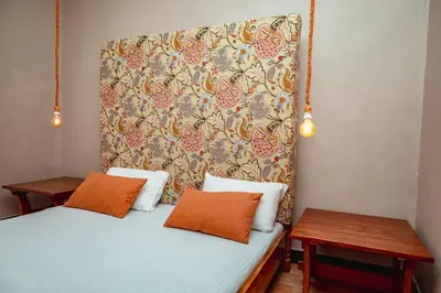 a bedroom with two beds and a headboard at Ghala House Apartment Moshi in Moshi