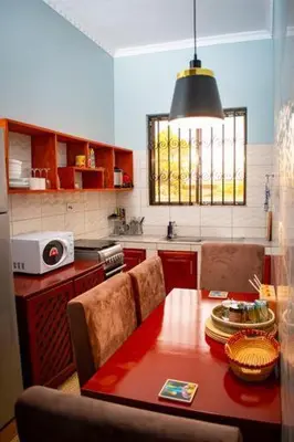 a kitchen with a wooden table and a dining room at ILBORU HAVEN HOMEs in Arusha