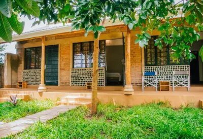 a house with a tree in front of it at Misitu Eco-Lodge in Karatu