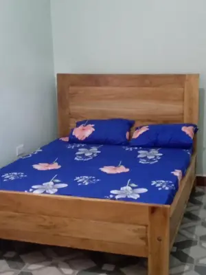 a bed with a blue comforter and blue pillows at Vanilla coffee farm lodge campsite in Arusha