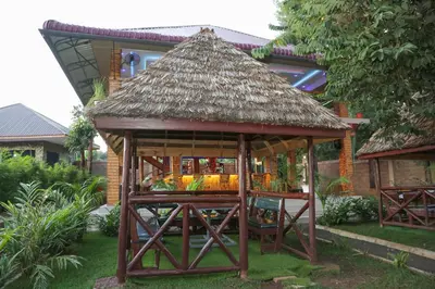 a gazebo with a thatched roof in a yard at Diamond Delight Boutique Hotels in Moshi