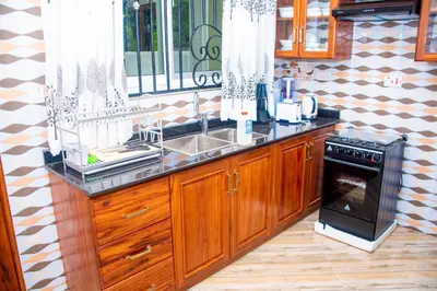 a kitchen with a sink and a stove at VvEK B&B APARTMENT in Arusha