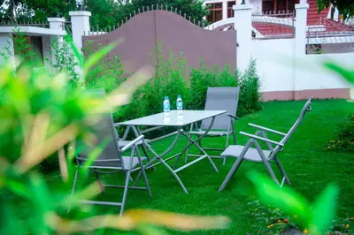 a table and chairs in a yard with grass at VvEK B&B APARTMENT in Arusha