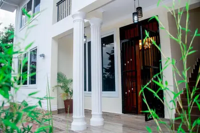 a front door of a house with white columns at VvEK B&B APARTMENT in Arusha