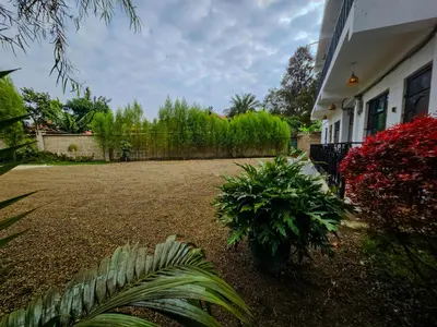a yard of a house with a fence and plants at Fly Africa Village 2 in Arusha